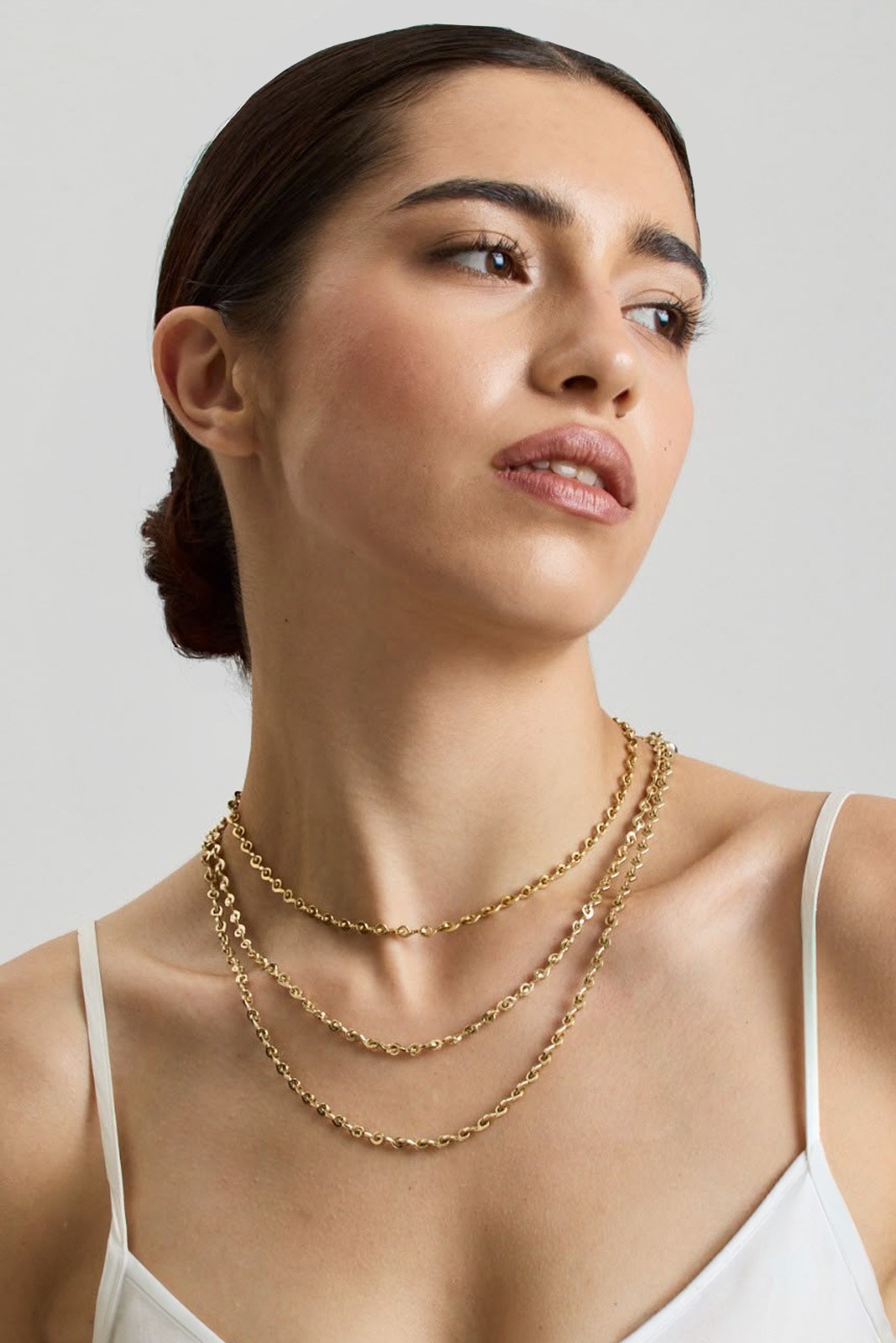 Two gold chains worn, one over the other