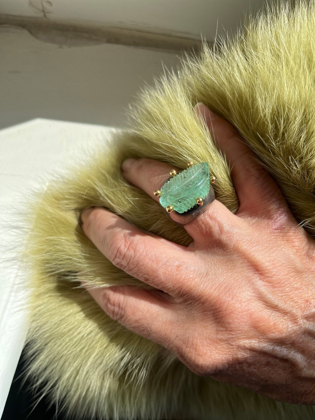 A green stone ring, worn